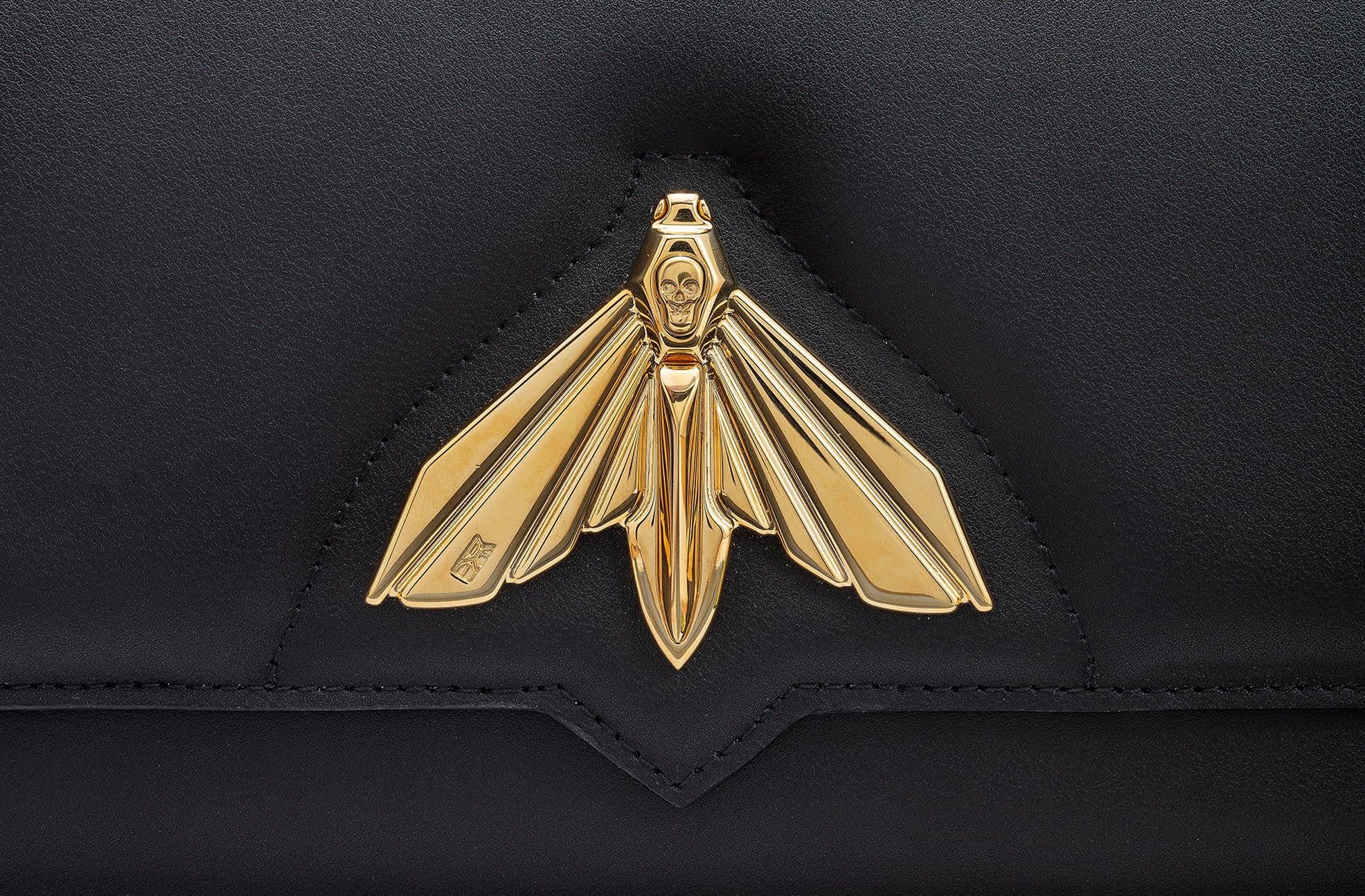 Fermoir dor&eacute; en forme de Grand Sphinx sur un rabat de sac en cuir noir